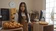 © Krakenimages.com - Woman at bakery counter with fresh pastries, standing in indoor shop setting with chinese decor elements, wearing brown apron, and smiling confidently in well-lit room