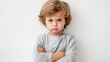 © ChimE - A young child stands with crossed arms, frowning in a striking display of frustration against a plain white background.