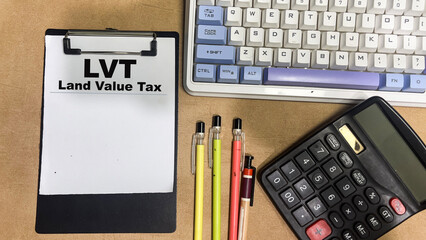 Wall Mural - Concept of LVT - Land Value Tax write on paperwork isolated on Wooden Table.