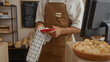 © Krakenimages.com - Young man in bakery cleaning with cloth near cash register counter in indoor shop