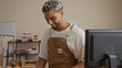 © Krakenimages.com - Handsome young muslim man with a beard smiling while working in an indoor bakery shop setting, suggesting a warm and inviting atmosphere.
