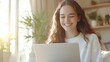 © Tondone - A young woman smiles joyfully while using a laptop in a cozy, sunlit room filled with plants, embodying the concept of remote work and modern technology.
