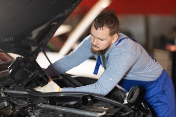 Wall Mural - Professional auto mechanic changing air filter in car engine