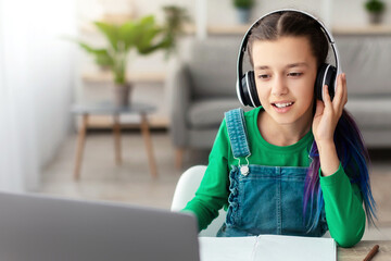 Poster - Good Connection, E-learning Concept. Portrait of teenafe girl touching wireless headphones, sitting at table, using pc computer and watching online tutorial, lecture or class, studying online at home