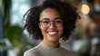 © addymawy - A smiling young woman with curly hair and glasses