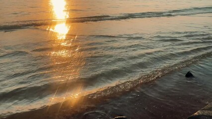 Wall Mural - view of waves rushing at sandy beach against sky during sunset.