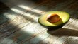 © Rizqiana - Halved avocado, sunlit wood, rustic table.