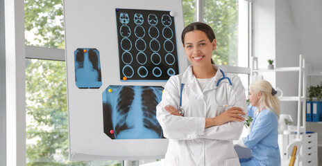 Poster - Female doctor near flipchart with x-ray images in clinic