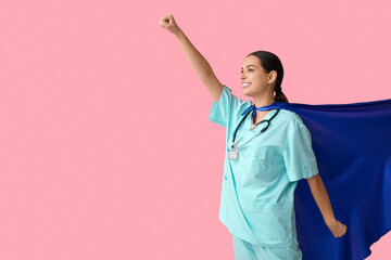 Poster - Beautiful female doctor in superhero costume on pink background