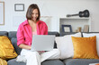 © Pixel-Shot - Teenage girl with laptop filling out online college application form on sofa at home