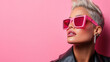 © siraphol - Bold neon makeup and stylish sunglasses against pink background