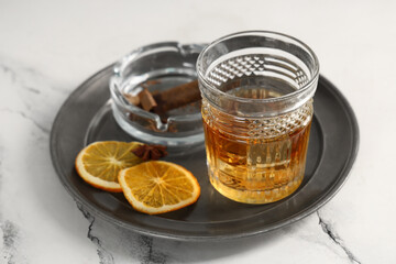 Wall Mural - Glass of rum, orange slices and cigar in ashtray on plate on table. Closeup