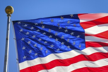 Wall Mural - American flag, detail, national flag, US-American flag blowing in the wind against a blue sky, USA, North America