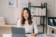 © ARMMY PICCA - Portrait of young asian woman working with laptop at home office.