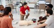© peopleimages.com - Mannequin, cpr and training with people and defibrillator for first aid workshop, cardiac arrest rescue or safety protocol. Healthcare class, medical simulation and heart rhythm with paramedic course