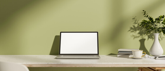 Canvas Print - a close-up of a laptop and decorative items on a white tabletop against a green wall.