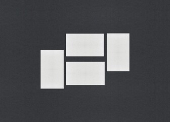Poster - Four white rectangles arranged in a staggered pattern on a dark gray background, Blank white Business card mockup stacks at grey textured paper background