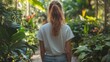 © zuriya - Stylish woman in white oversized t-shirt walking through botanical garden, greenery and plants framing the t-shirt, urban chic vibe
