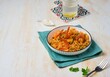 © Natallya_ph - Orzo pasta with carrots, green peas and shrimps with tomato sauce in a white plate on a light concrete background. Seafood recipes.