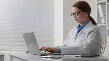 Poster - A dedicated healthcare professional, like a doctor or nurse, works on a laptop in a modern office, showcasing commitment to innovation, improvement, and effective clinical solutions for patient care