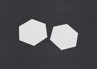 Poster - Two white hexagons on a dark background create a minimalist geometric composition, Blank white Business card mockup stacks at grey textured paper background