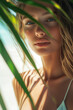 © ALL YOU NEED studio - stunning tropical beach scene featuring a woman in a white bikini basking in the sunlight, standing on pristine white sand under the shade of palm leaves casting delicate shadows on her skin