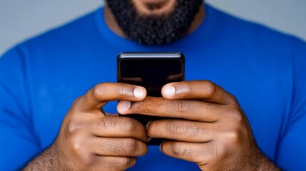 Poster - Man with a beard is holding a cell phone in his hand. He is looking at the screen, possibly texting or browsing the internet. Concept of modern technology