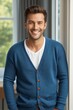 © haiqiang - arafed man in a blue cardigan standing by a window
