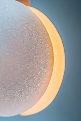 Poster - A frosted glass surface casts a warm glow from a circular light source behind it, creating a soft halo effect. This composition radiates an elegant and contemporary atmosphere
