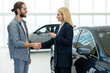 © zinkevych - Female dealership representative talking to a male customer and looking involved