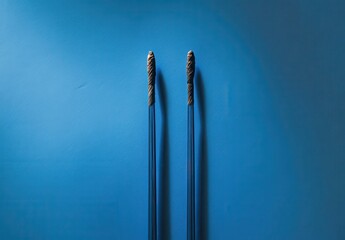 Poster - Blue background with two textured blue sticks creating a minimalistic abstract composition, conveying simplicity and elegance in design