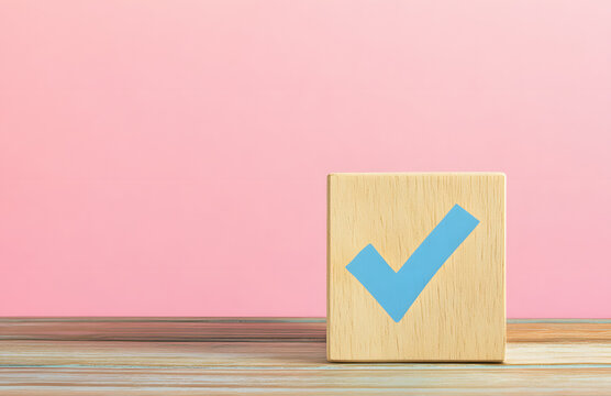 Wooden cube with a blue checkmark on a wooden table, isolated on a pastel background with copy space for text