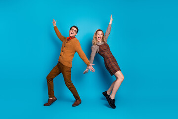 Wall Mural - Young couple posing with joyful expressions against a vivid blue background