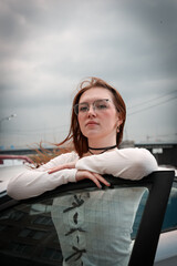 Wall Mural - A young model in her 20s in light-colored jeans walks around the city. Mild spring weather. Local tourism.