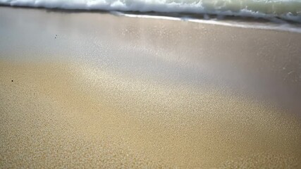 Wall Mural - Enjoying the gentle waves and soft sand on a tropical beach during a bright sunny day, Close up of sand beach of tropical sea coast White foam wave washes on shore