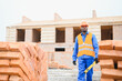 © Serhii - African american Bricklayer industrial worker installing brick masonry on exterior wall with trowel putty knife