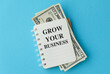 © Pawel - Grow Your Business Inscription on open notepad with money inside on a white background
