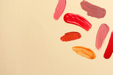 Wall Mural - Samples of different lip products on beige background, top view. Space for text