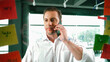 © Summit Art Creations - Professional businessman making phone call to customers while looking at marketing strategy idea written on colorful sticky notes. Project manager talking on phone analysis data on wall. Manipulator.