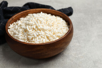 Wall Mural - Puffed rice in bowl on light grey table, closeup