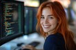 © stockphoto02 - A smiling redhead woman programmer is working on her computer, focused on lines of code.