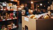 © ma - A cardboard box of food items is seen in the foreground, with shelves and people blurred out behind it. The focus on close-up details like labels or branding conveys an urban warehouse setting.