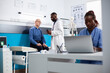 © DC Studio - Friendly physician holds prescription bottle while explaining treatment plan to elderly male patient. Caucasian retired man sits in clinic office receiving medication from doctor for his recovery.