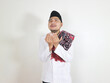 © vicky - Asian Muslim man in Islamic clothing shows a gesture of praying to God with a pitiful expression. concept of Islamic religious people. celebrate Ramadan and Eid Mubarak