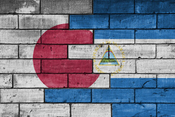 Canvas Print - colourful painted big flag of japan and flag of nicaragua on a massive old brick wall background. concept