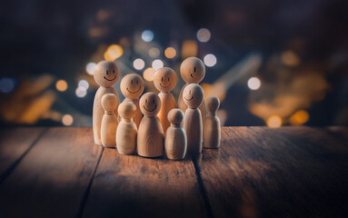 Aufkleber - A group of wooden figurines with smiley faces stand together on a wooden surface with a blurry background of warm lights.