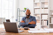 © David - Happy African American Businessman with arms crossed standing in the office and looking at camera.