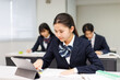 © Paylessimages - 携帯電話を使って勉強するアジアの 10 代の少女