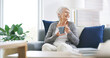 © peopleimages.com - Coffee, smile and thinking with senior woman on sofa in living room of retirement home for break. Drink, relax and wellness with happy mature person in apartment for idea, planning or vision
