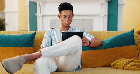 Fototapete - Tablet, reading and man on sofa in home with email for university scholarship admission with education. Relax, technology and male student with online contact for college acceptance in living room.